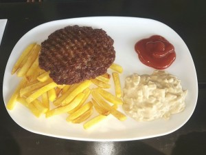 Pljeskavica mit Pommes, Zwiebelsenf und Ketchup