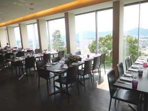 Gastraum - Tische an der Glasfront mit Blick über Graz