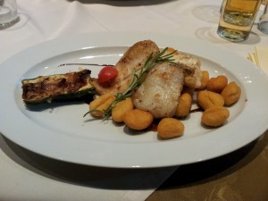 Hauptgang eines Mittagsmenüs: Mediterrane Fischvariation vom Grill auf gebackenen Gnocchi und ...