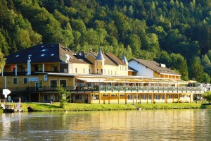 Blick von der Donau auf das Hotel mit der großen vorgelagerten Terrasse