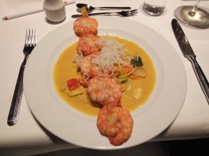 Black-Tiger-Prawns auf gelbem Curry mit Hummerchipsstroh