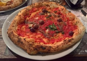 Pizza Siciliana, mit Paradeissauce, Sardellen, Oliven, Kapern, Knoblauch, Olivenöl und Oregano ...