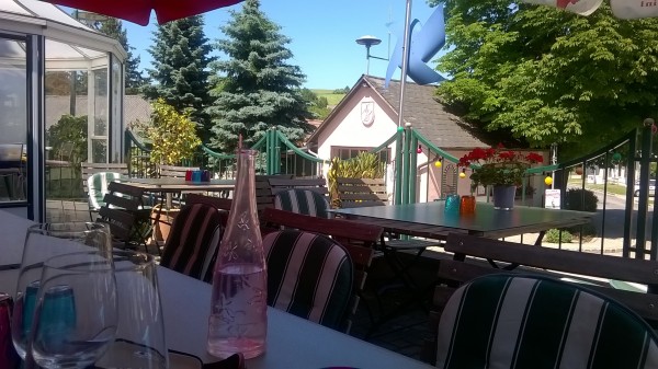 Holztisch mit Glasplatte, oben drauf eine Staude, bunte Wassergläser und ... - Buchingers Gasthaus - RIEDENTHAL