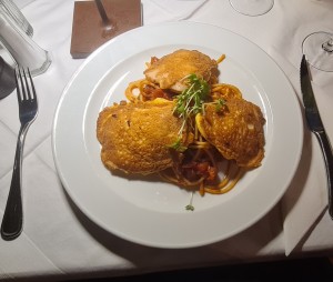 Hühnerbrustschnitzeln im Parmesan-Eimantel serviert auf Tomatenspaghetti - Da Capo - Wien