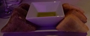 Gedeck bestehend aus zwei Sorten Brot (Weißbrot und Nussbrot) in der Mitte ein Schälchen Olivenöl