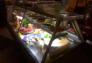 Vitrine mit einigen wenigen Köstlichkeiten, rechts die offen Küche..... - Osteria Dal Toscano - Wien