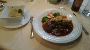 Im Ofen geschmortes Rinderbackerl in kräftiger Rotweinsauce mit frischem Gemüse und Serviettenknödel