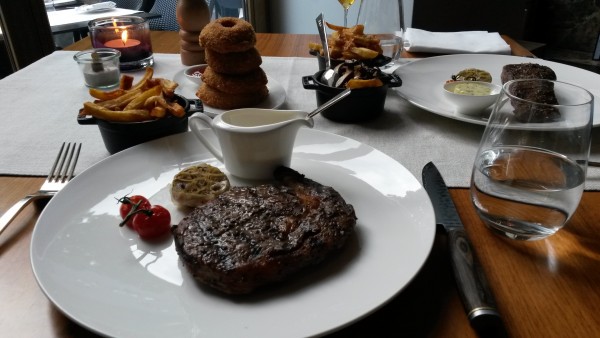 Ribeye, 300 g mit Sauce béarnaise. Im Hintergrund: Zwiebelringe, Handcut ... - DSTRIKT - Wien