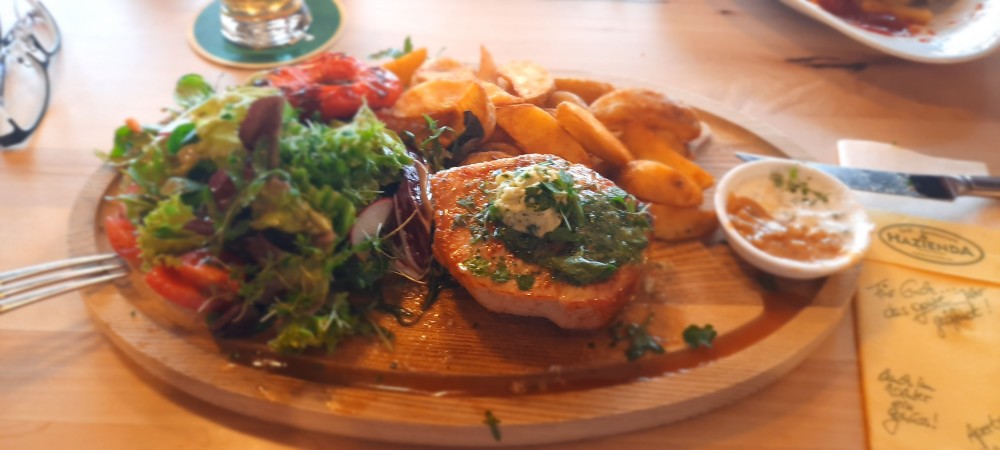 Schweinsrückensteak auf Holzbrett mit Salatgarnitur - Hazienda - Drobollach