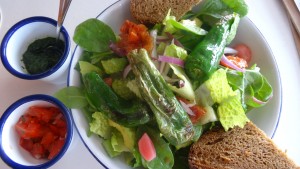 Salat mit Avocado, Ofenparadeiser, Pimentos, Babyspinat, roter Zwiebel, eingelegten Radieschen 